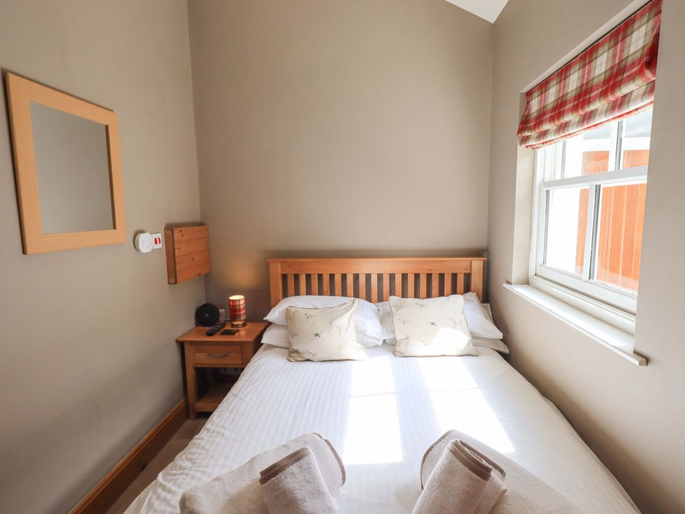 A bedroom with a bed and nightstand at Abbots Reading Suite, Lakeside