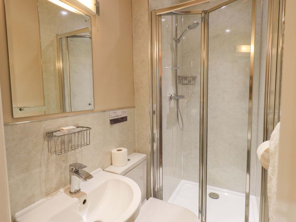 A bathroom with a sink, toilet and shower at Abbots Reading Suite in Lakeside