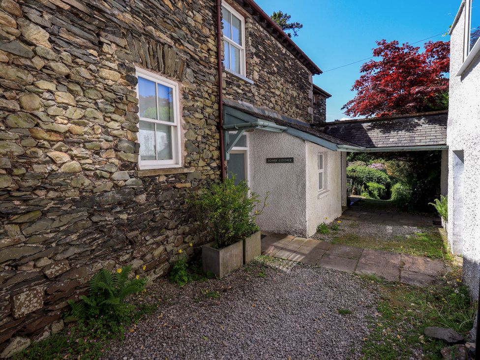 An outdoor area with stone walls and a pathway at Tower Cottage in Windermere