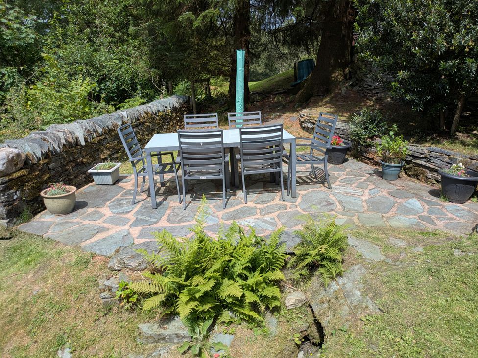 A garden with a table and chairs at Wythebank in Langdale