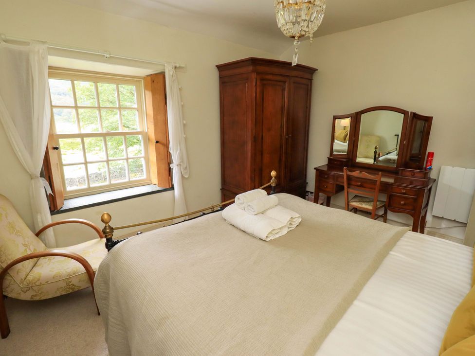A bedroom with a bed, wardrobe, and dressing table at Beck Steps in Chapel Stile