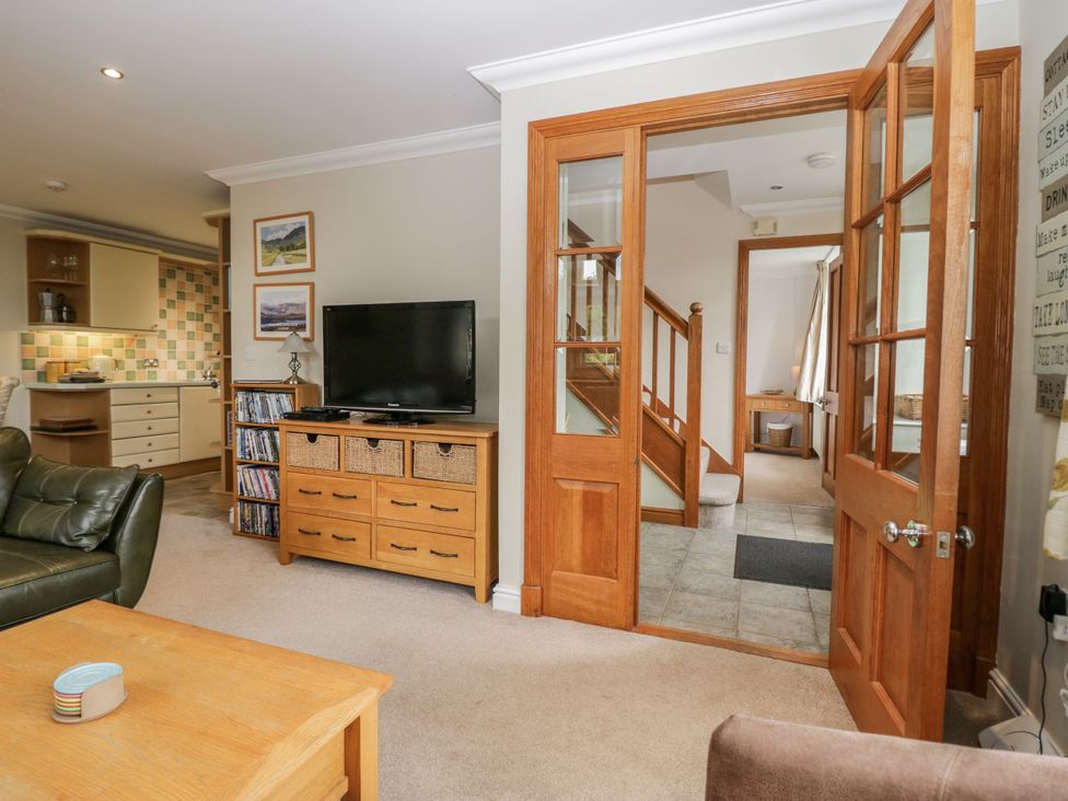 A living room with a sofa, coffee table, and TV at Middlerigg in Troutbeck