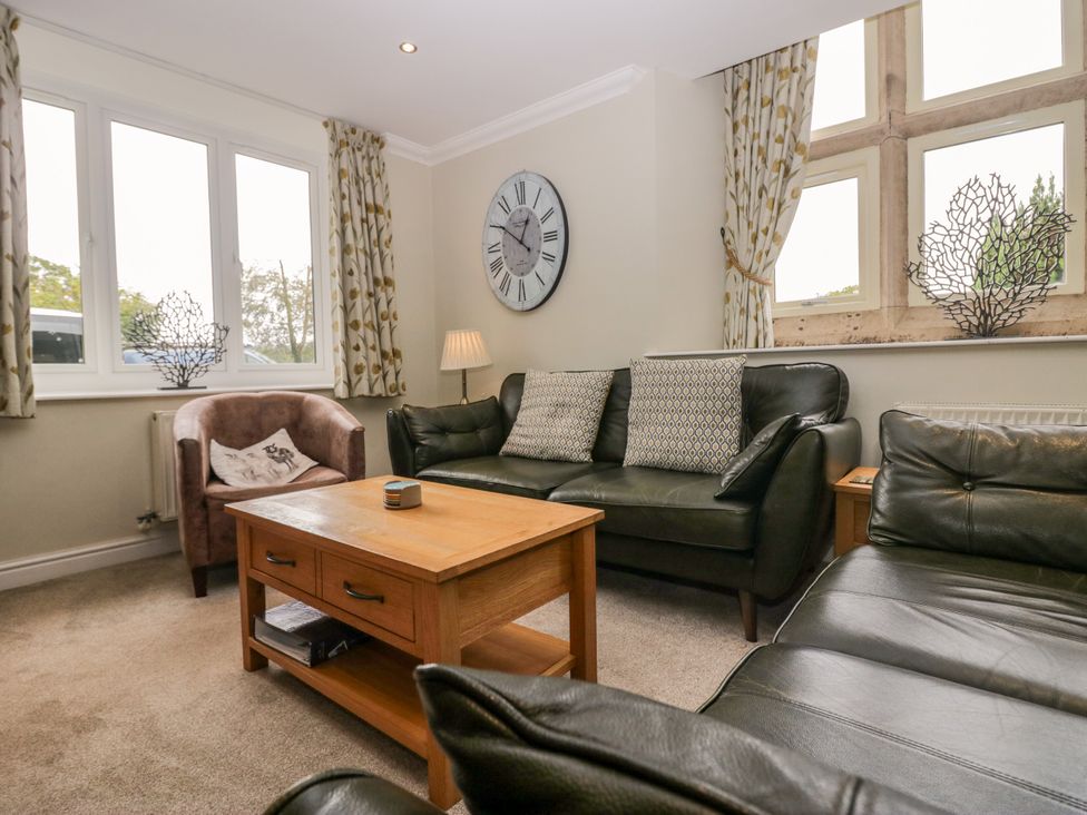 A living room with a sofa, armchair and coffee table at Middlerigg in Troutbeck