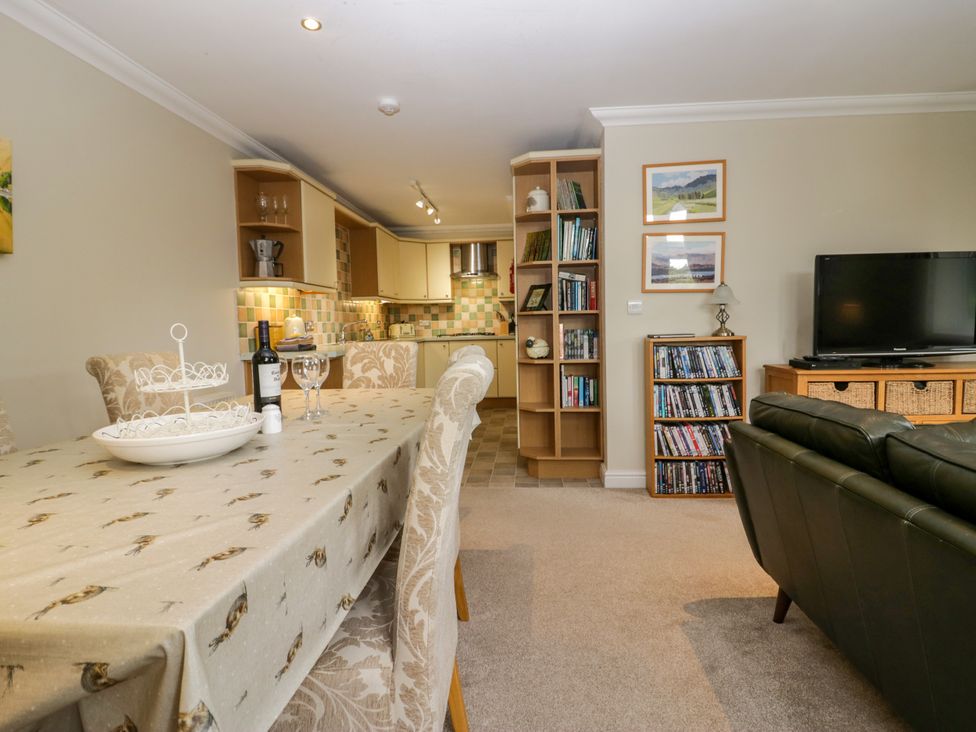 An open plan living and dining area with a table and kitchen at Middlerigg in Troutbeck