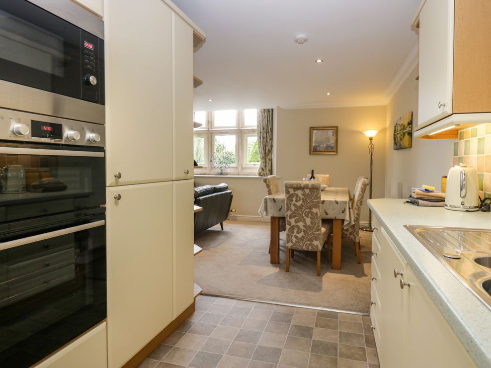 A kitchen area with appliances and a dining table at Middlerigg in Troutbeck