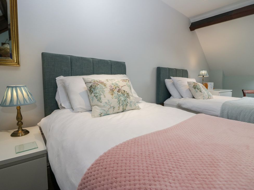 A bedroom with two beds and a lamp at Middlerigg in Troutbeck