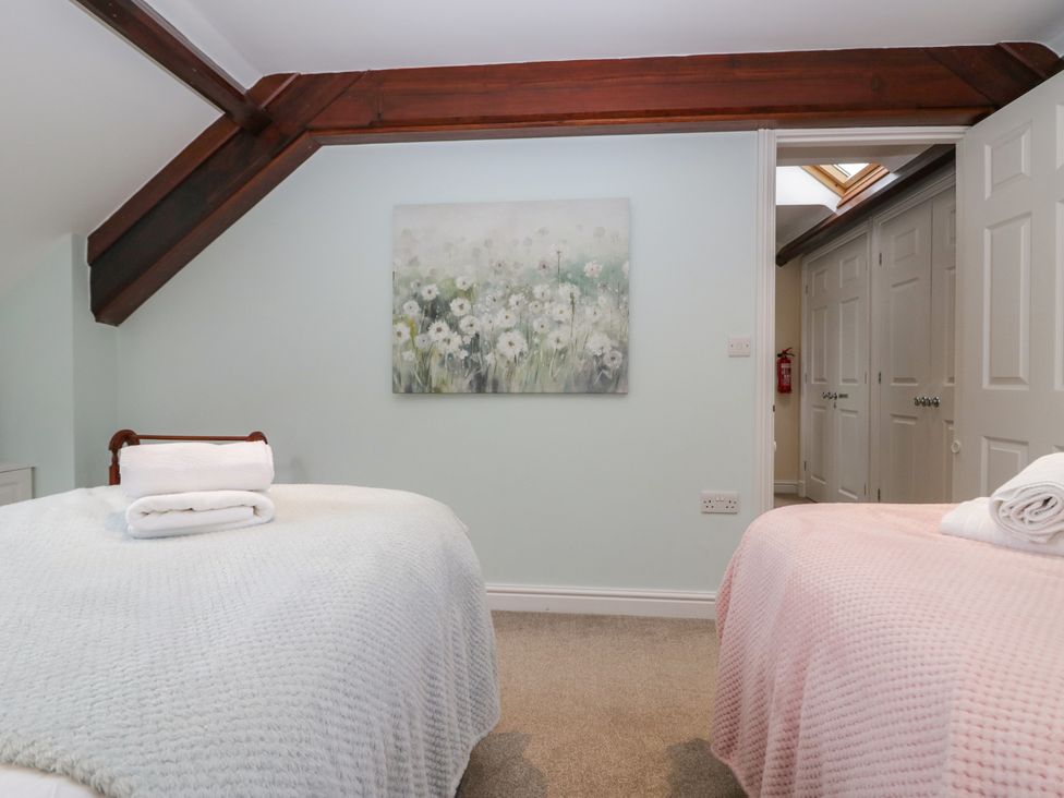A bedroom with two beds and a painting at Middlerigg in Troutbeck