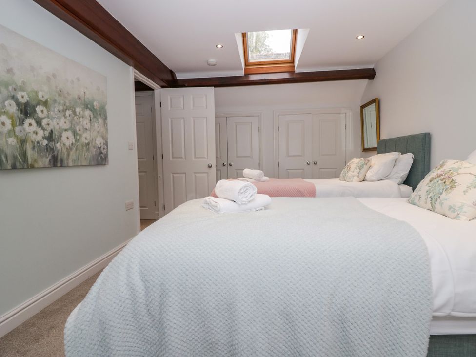 A bedroom with two beds and a painting at Middlerigg in Troutbeck