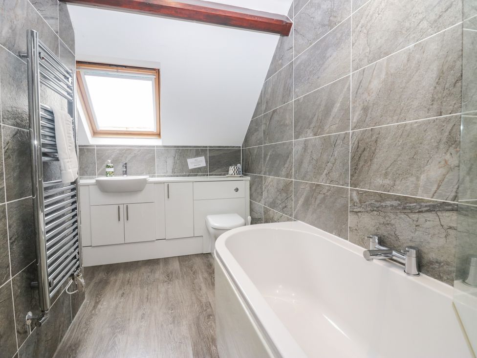 A bathroom with a bathtub, sink, and toilet at Middlerigg in Troutbeck