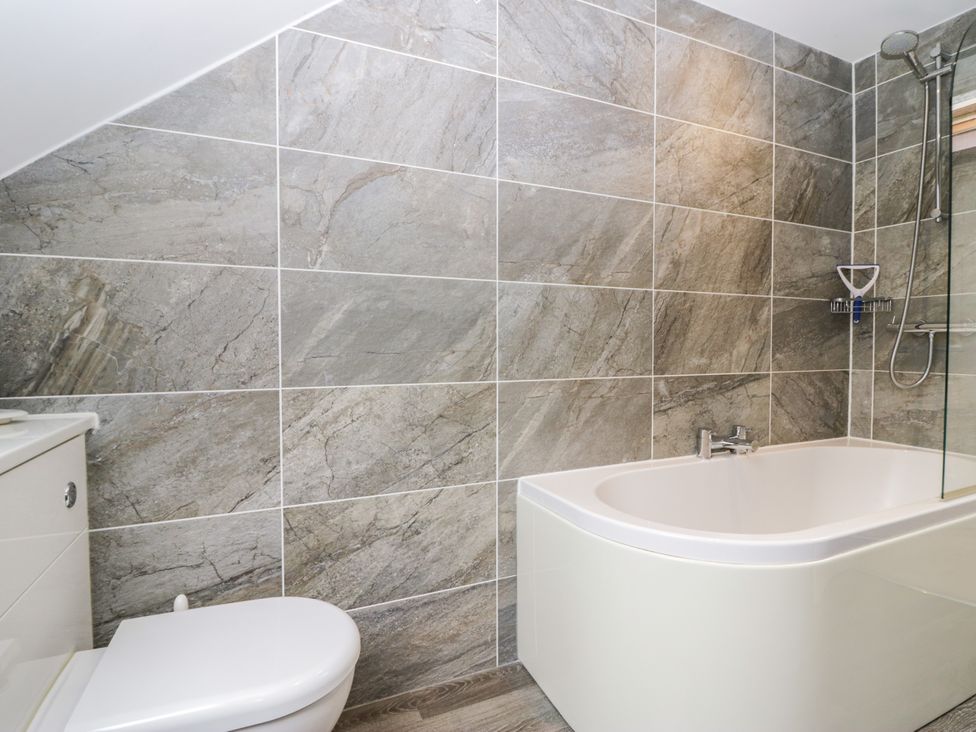 A bathroom with a bathtub and toilet at Middlerigg in Troutbeck