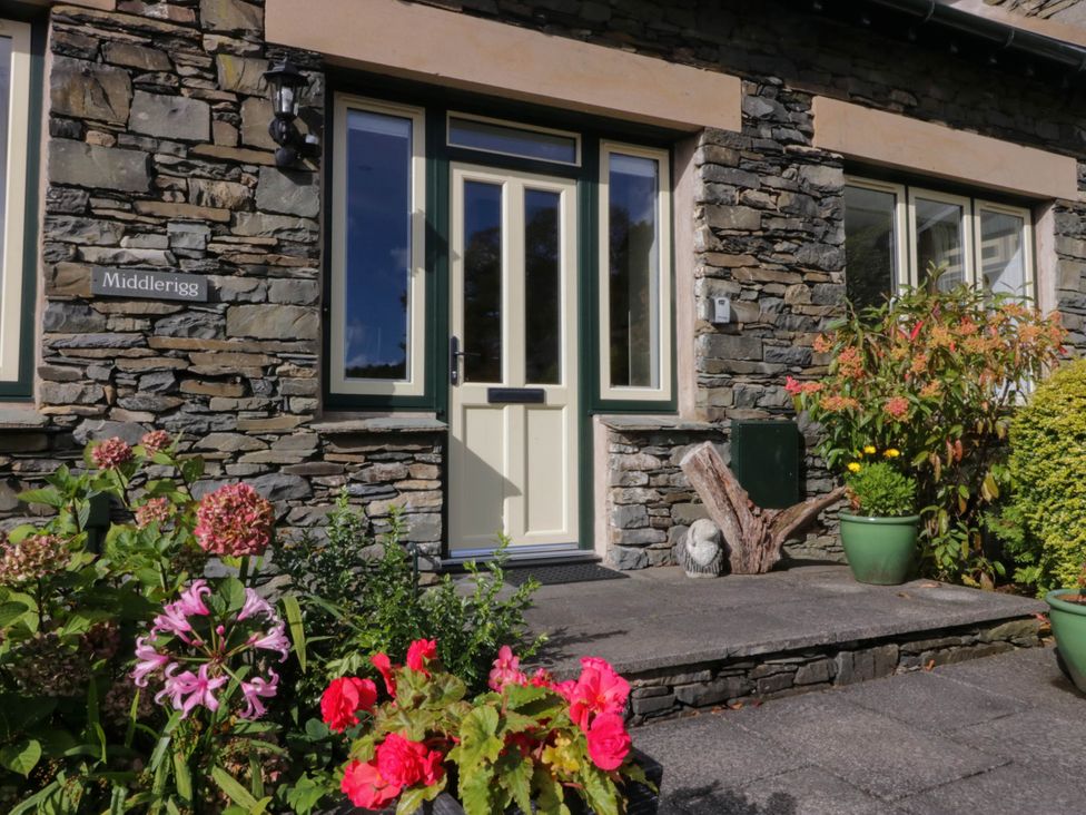 An entrance with flowers and a stone wall at Middlerigg in Troutbeck