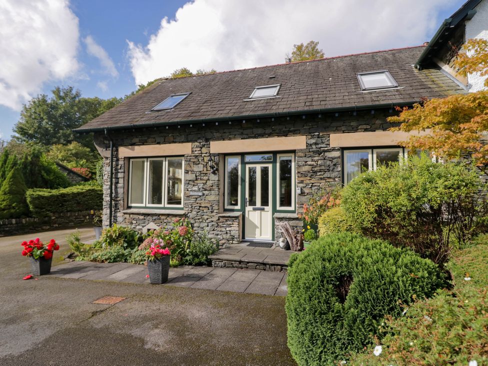A house with a stone exterior and flowers in planters at Middlerigg in Troutbeck