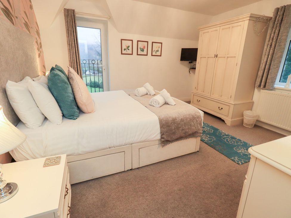 A bedroom with a bed and wardrobe at Fairfield Cottage in Grasmere