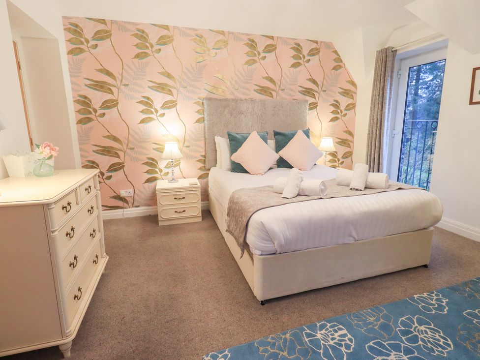 A bedroom with a bed and bedside table at Fairfield Cottage in Grasmere