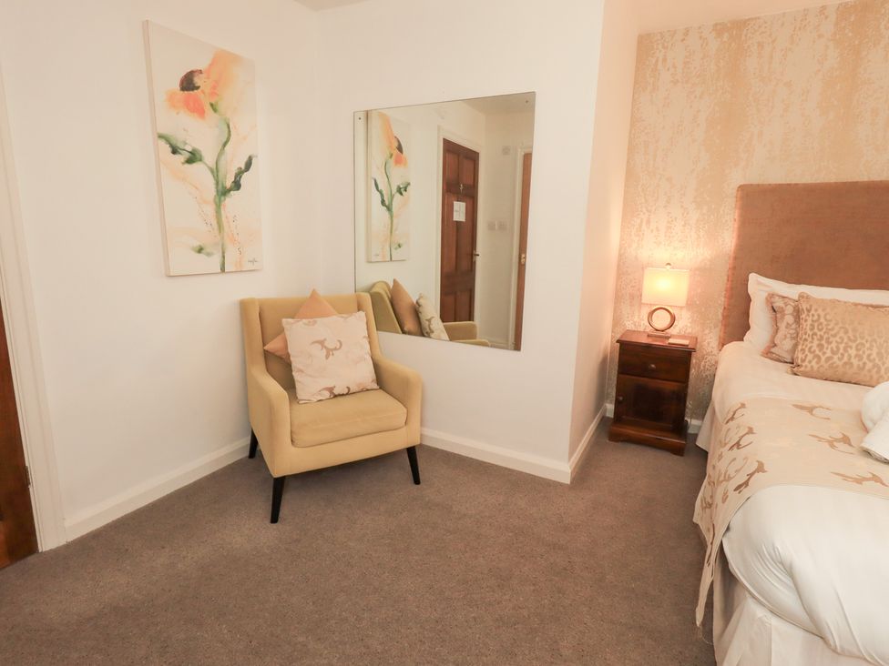 A bedroom with a bed and mirror at Fairfield Cottage in Grasmere