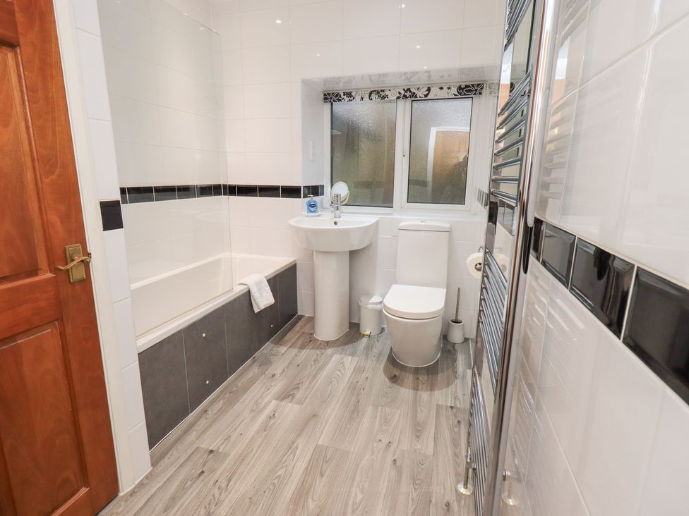 A bathroom with a tub, sink, and toilet at Fairfield Cottage in Grasmere