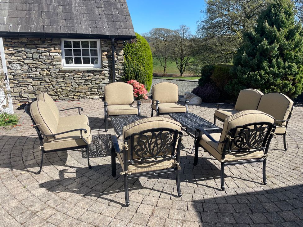 An outdoor seating area with chairs and a table at Bank Barn at Rusland, Grizedale