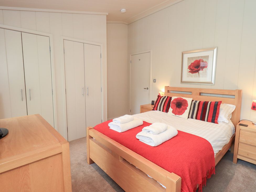 A bedroom with a bed and wardrobe at Thie Loghey in Hawkshead