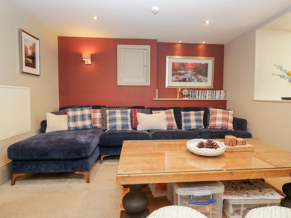 A living room with a sofa and wooden table at Archie's in Ambleside