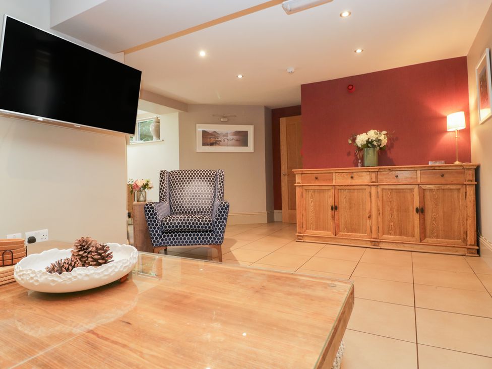 A living room with a television and an armchair at Archie's in Ambleside