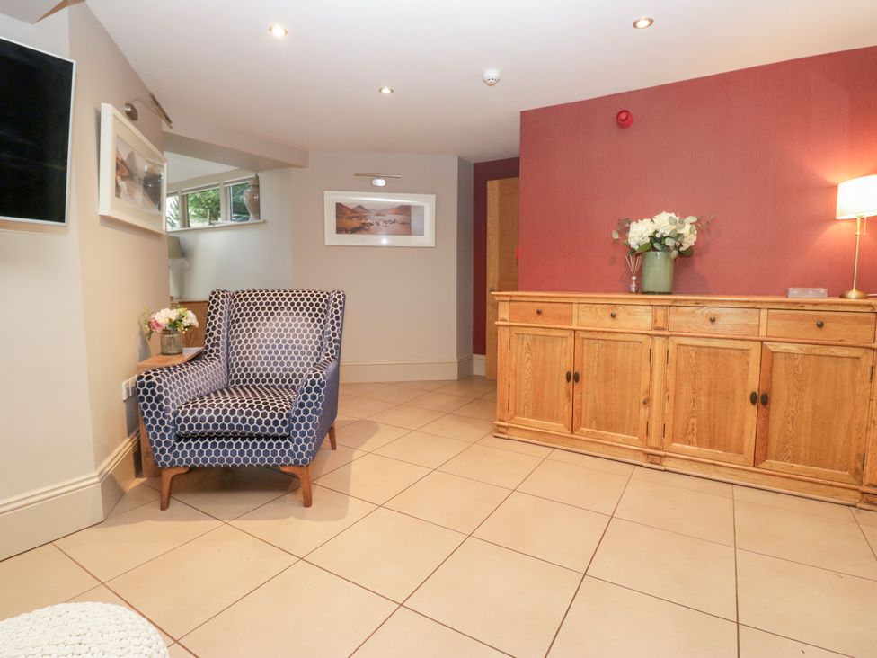 A living room with a chair and table at Archie's in Ambleside