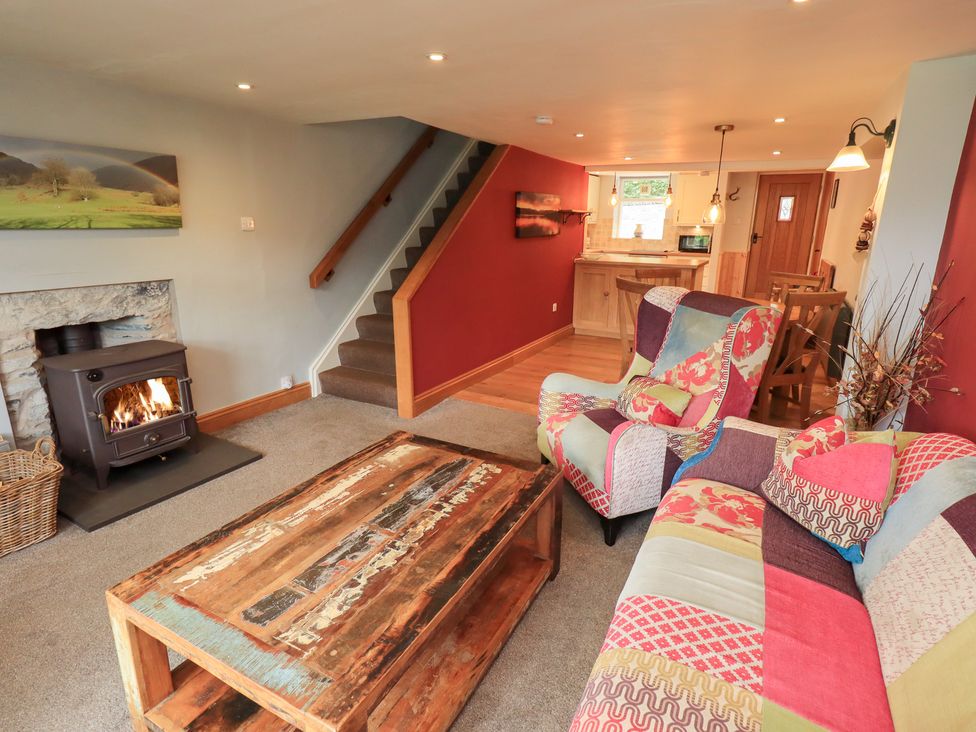 A living room with a stove and a coffee table at Boxwood Cottage in Troutbeck