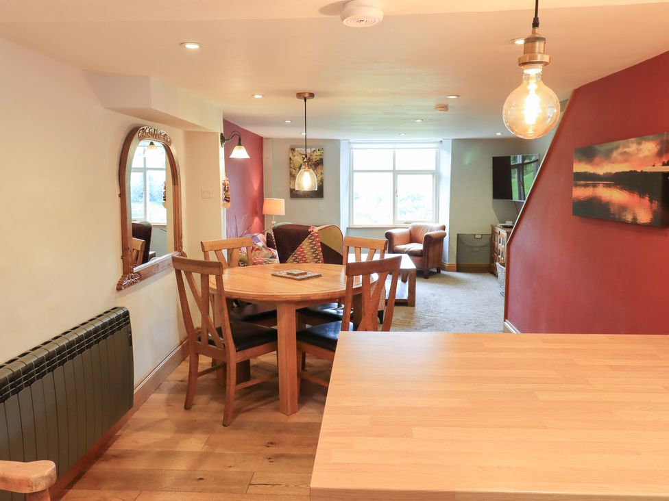 A living room with a table and chairs and a sofa at Boxwood Cottage in Troutbeck