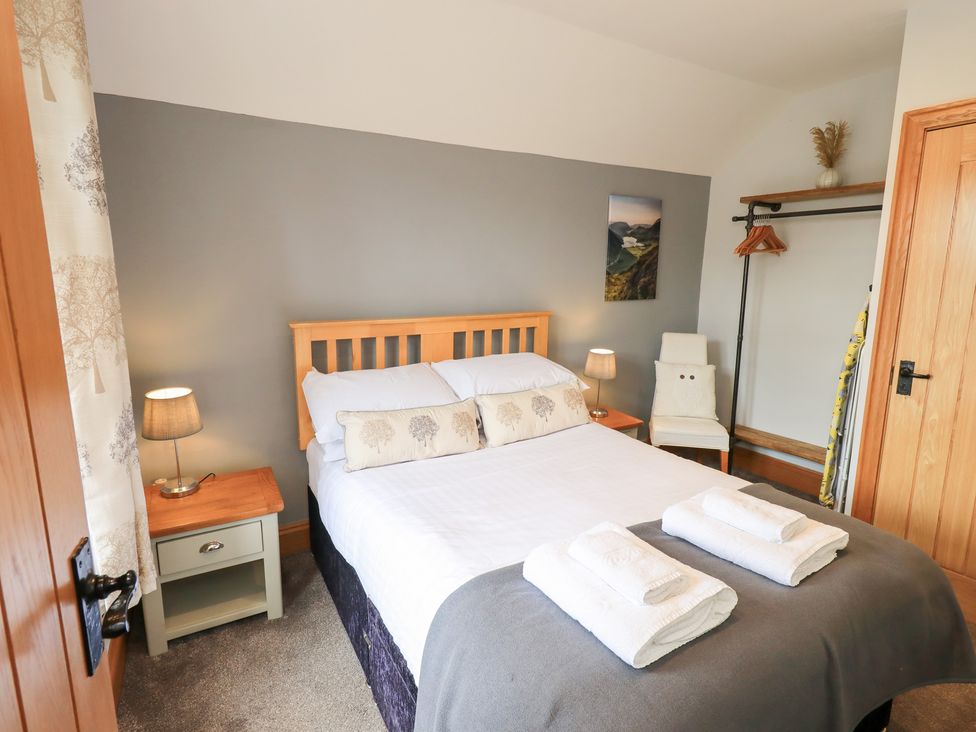 A bedroom featuring a bed and lamps at Boxwood Cottage in Troutbeck