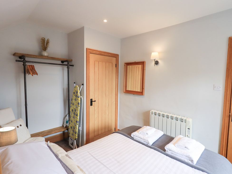 A bedroom with a bed and wardrobe space at Boxwood Cottage in Troutbeck