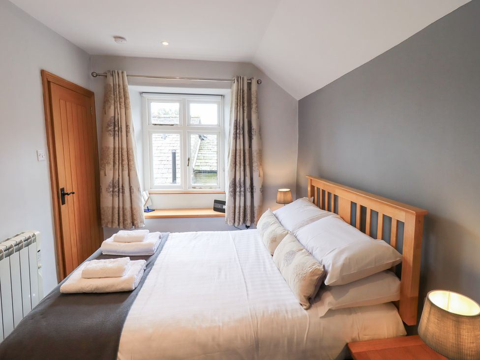 A bedroom with a bed and window at Boxwood Cottage in Troutbeck