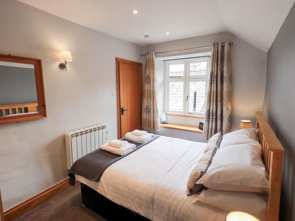 A bedroom with a bed and window at Boxwood Cottage in Troutbeck