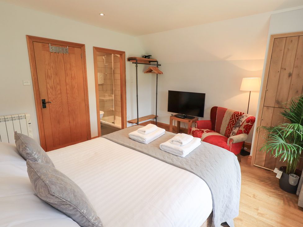 A bedroom with a bed and a television at Boxwood Cottage in Troutbeck