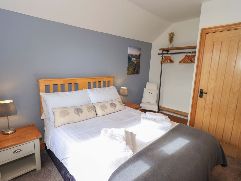 A bedroom with a bed and bedside table at Boxwood Cottage in Troutbeck