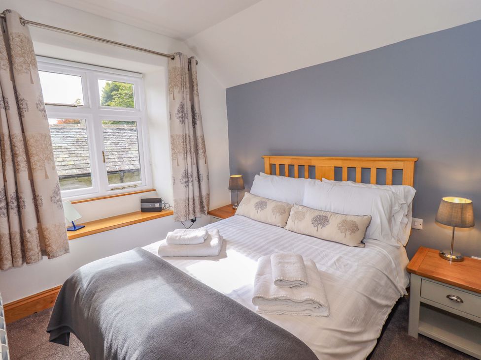 A bedroom with a bed and window at Boxwood Cottage in Troutbeck