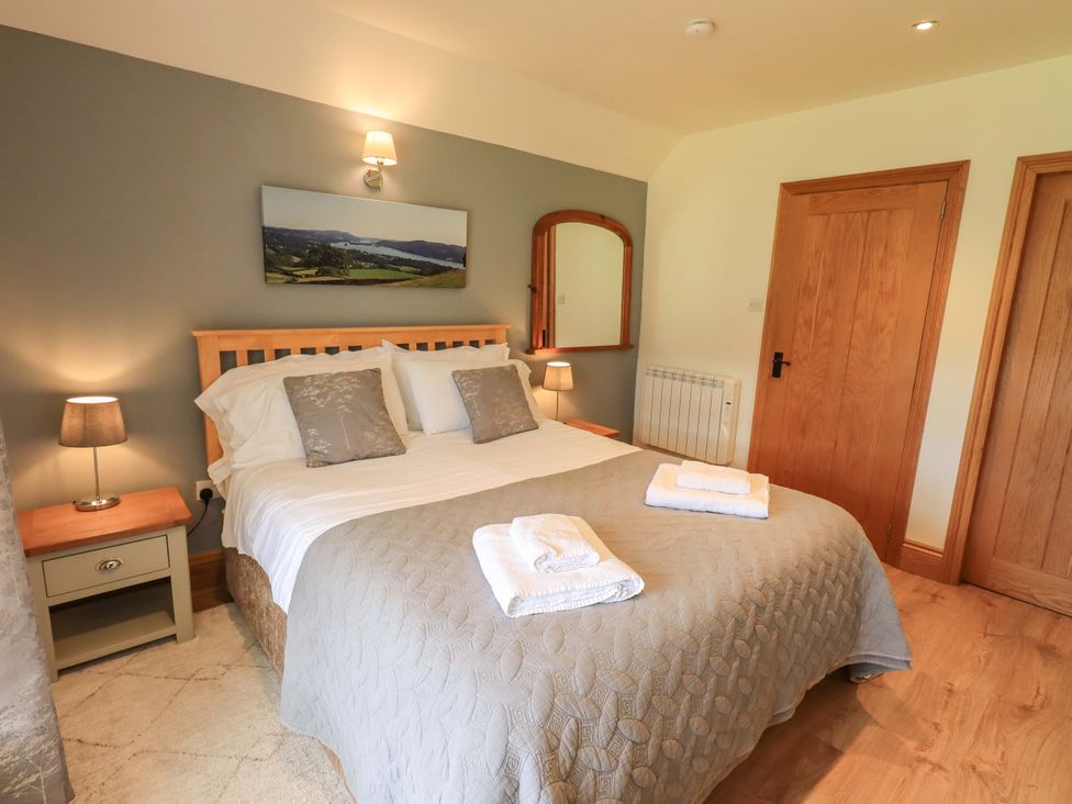 A bedroom with a bed and nightstand at Boxwood Cottage in Troutbeck