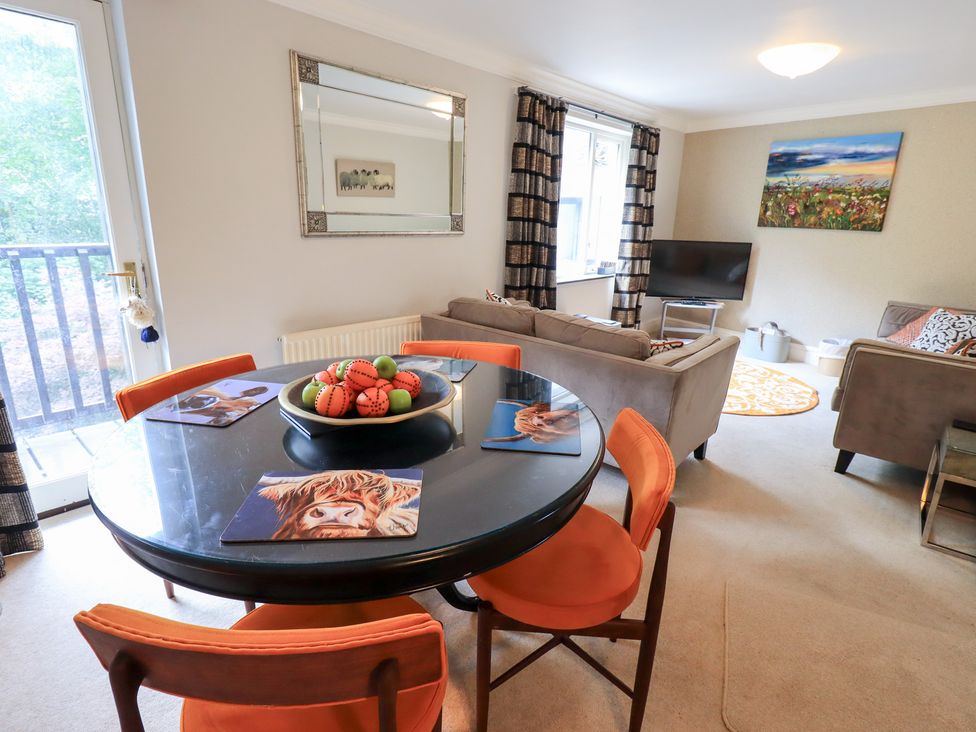 A living room with a dining table and couch at Ghyll Heights in Ambleside