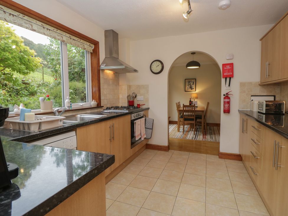 A kitchen with cooking range and dining table at Redwood in Ambleside