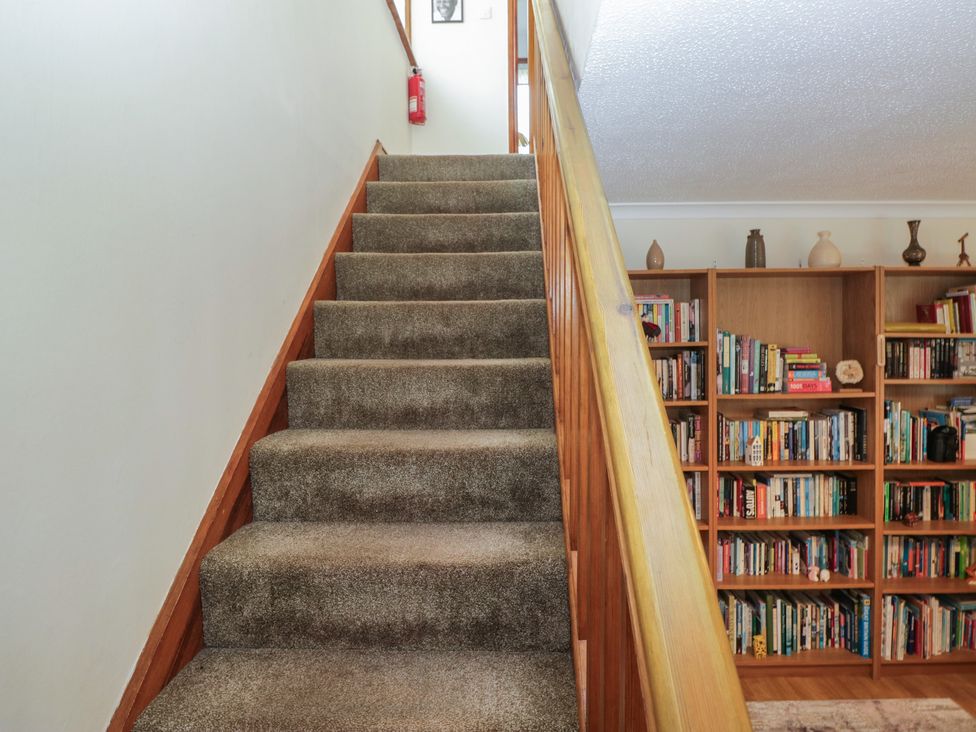 A staircase with a bookshelf and a fire extinguisher at Redwood in Ambleside