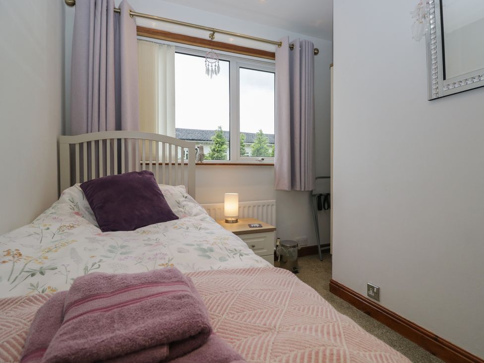 A bedroom with a bed and lamp at Redwood in Ambleside