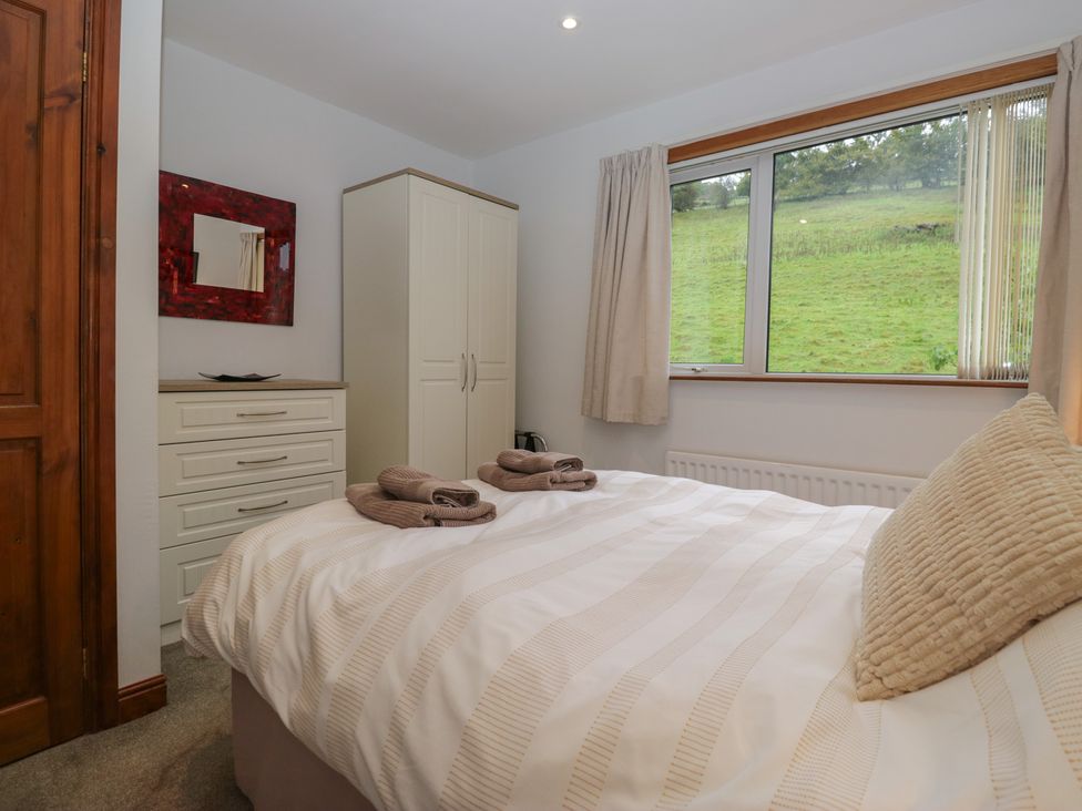 A bedroom with a bed and dresser at Redwood in Ambleside