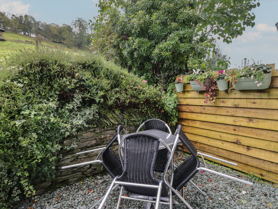 A garden with stacked chairs and planter boxes at Redwood in Ambleside