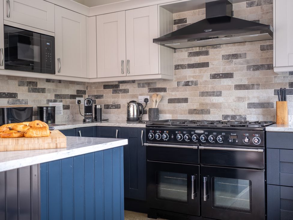 A kitchen with a cooking range a coffee machine and pastries at Goody Raise in Grasmere