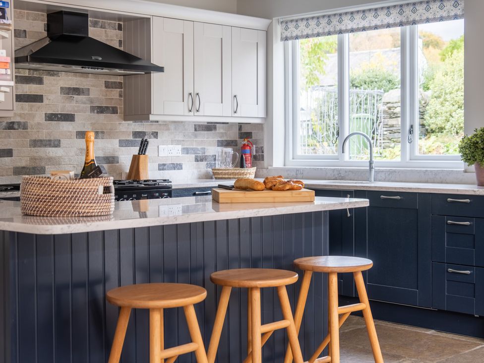 A kitchen with a table and stools at Goody Raise in Grasmere