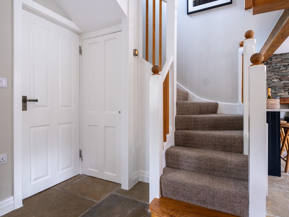 A hallway with stairs and doors at Goody Raise in Grasmere