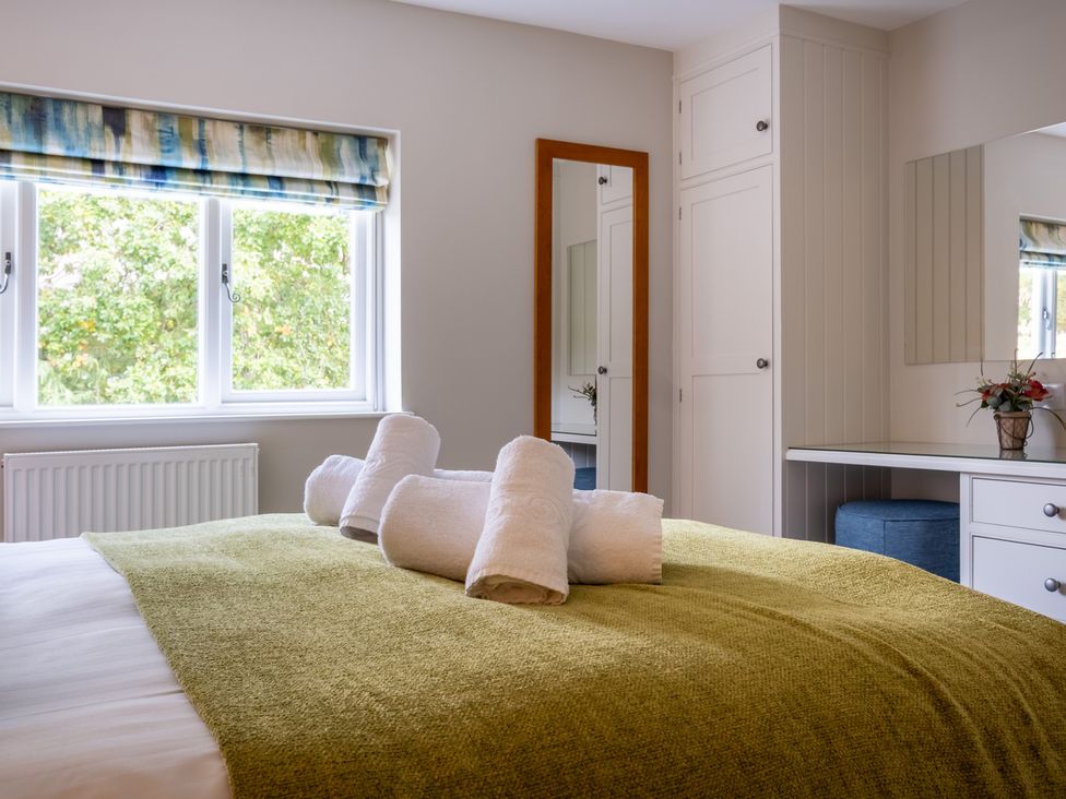 A bedroom with a bed and towels at Goody Raise in Grasmere