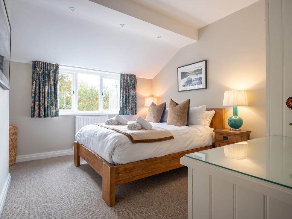A bedroom with a bed and window at Goody Raise in Grasmere