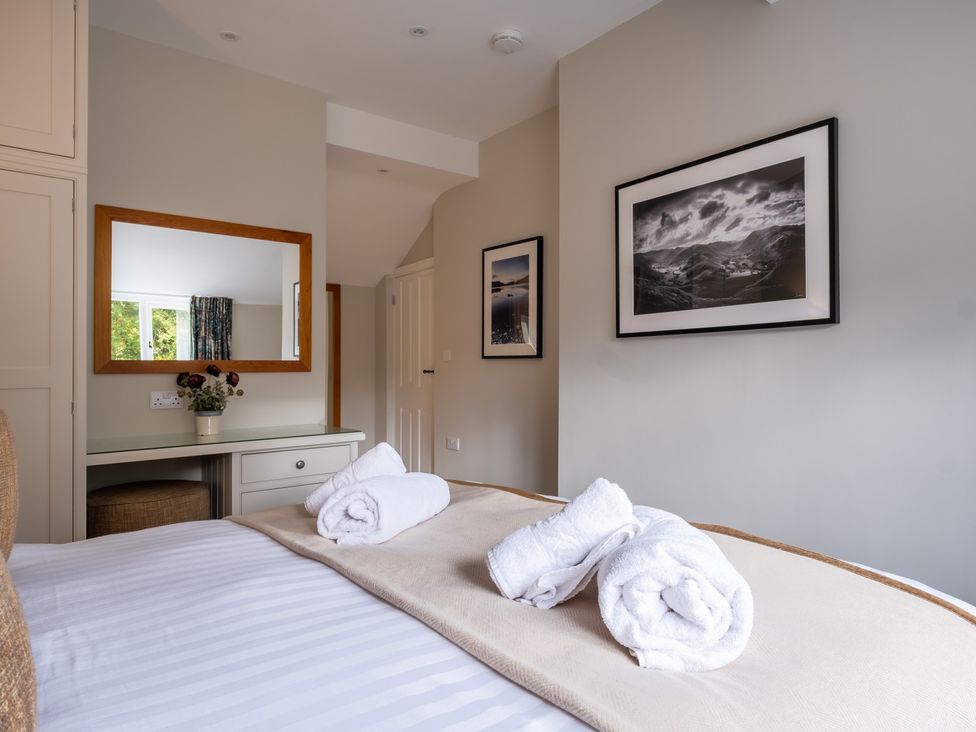 A bedroom with a bed and towels at Goody Raise in Grasmere