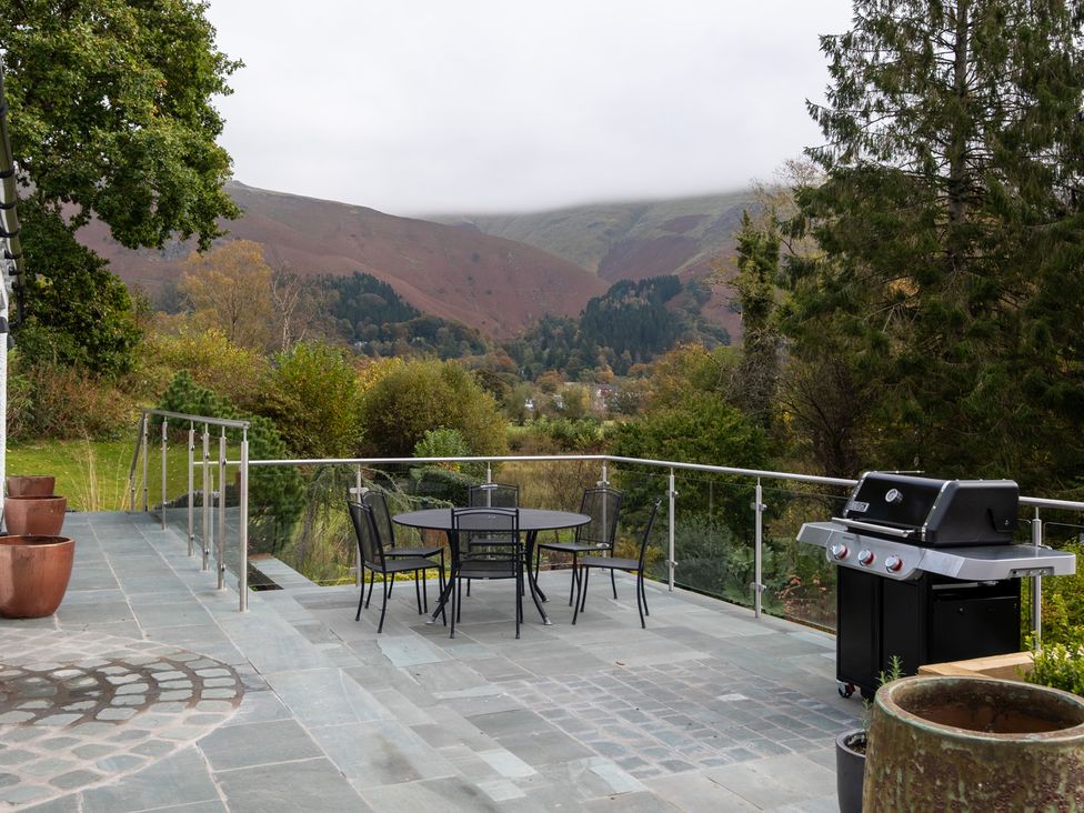 An outdoor patio with a table and chairs and barbecue at Goody Raise in Grasmere