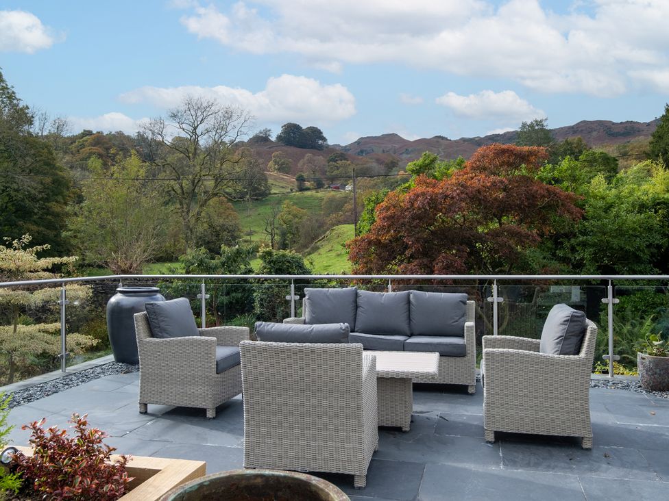 An outdoor patio with seating and a mountain view at Goody Raise in Grasmere