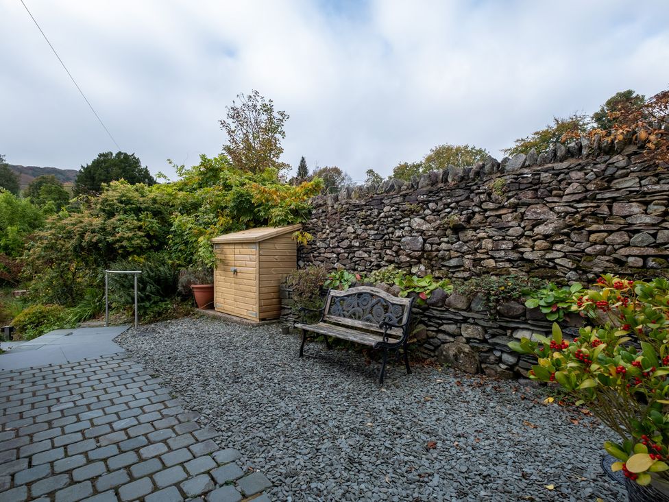 A garden with a bench and a shed at Goody Raise in Grasmere